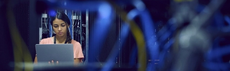 Technician using laptop in server room