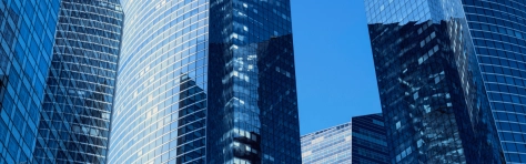 Modern glass office buildings reflecting the blue sky in a financial district in a European city
