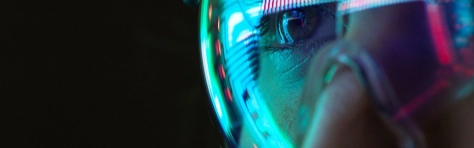 Close-up of a person's eye wearing futuristic neon glasses reflecting digital data patterns, symbolizing advanced AI technology and innovation in consulting services.