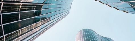 Low angle view of a curved building with glass and steel facade in Barcelona, Spain.