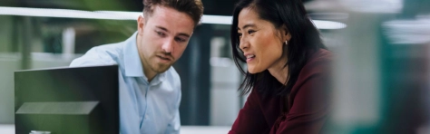 Two colleagues of a financial services firm working on their Consumer Duty Board Report.