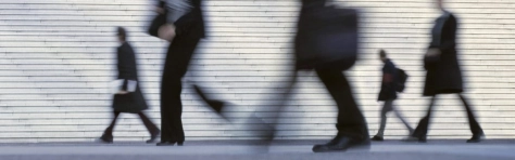 Morning image with businesswomen, businessmen and office workers (motion blurred) arriving at business district of Paris, France.