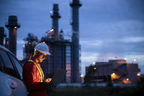 Factory worker at work looking at a laptop