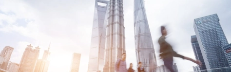 skyline di palazzi con davanti persone che camminano