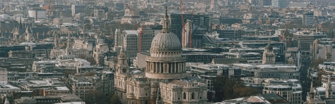 View of central London skyline in sunny daytime scene. St Pauls Cathedral with tall British city skyscrapers in England, UK.