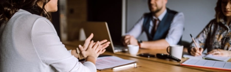 An image of a group of professionals in a meeting looking at a report