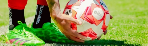 Premier league winning player about to kick football before receiving their tax bill.