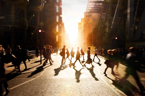 people walking through pedestrian. Sunset is in the background