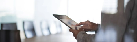 uomo che tocca un tablet con sopra l'immagine di un grafico