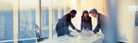 gruppo di colleghi lavora in una sala meeting con una vetrata sulla città