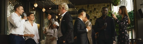 gruppo di persone che parlano e bevono con calici in mano