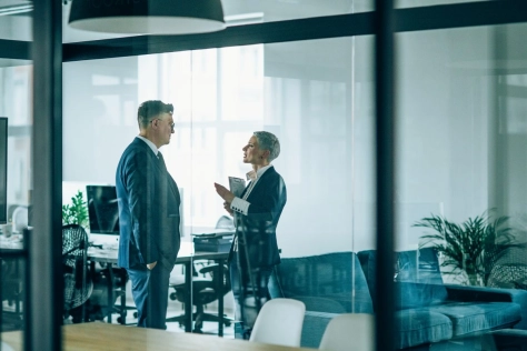 2 people standing in an office and discussing something