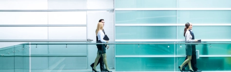A businessman and businesswoman walking in the office