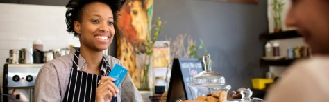 Image of coffee shop assistant speaking to a customer