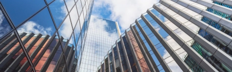 Modern glass and steel built office buildings in London business district with clouds overhead