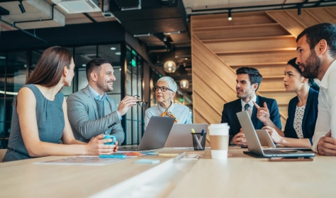 Business professionals discussing financial and regulatory topics during a meeting, illustrating insights from the Swiss Tax Newsletter.