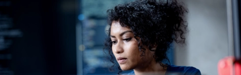 Improve Automate Workflows and Streamline Software Testing with Machine Learning in Software Development. An Asian female software developer coding or debugging code on a computer at her desk in the tech office.