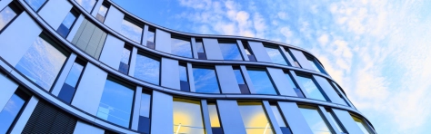 An image of an office building with a blue sky background