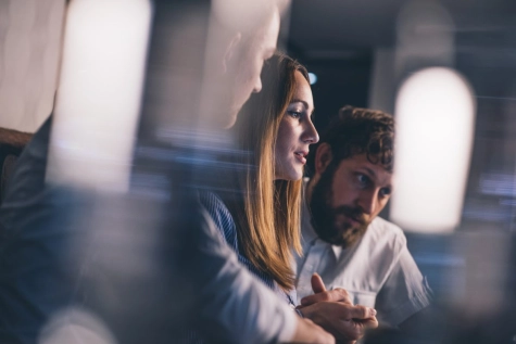 Woman sitting with colleague behind the desk
