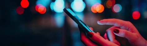 A close up image of a hand holding a telecommunication device.