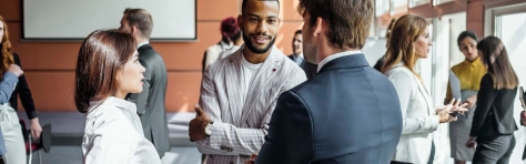An image of a group of professionals talking and networking at a business forum