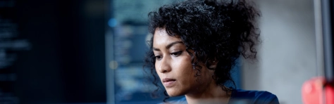 Improve Automate Workflows and Streamline Software Testing with Machine Learning in Software Development. An Asian female software developer coding or debugging code on a computer at her desk in the tech office.