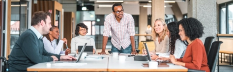 An image of a group of colleagues at a meeting in an office.