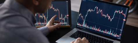 Man checking the stock market and investments using his laptop.