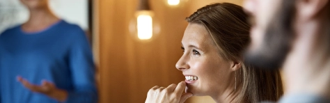 Smiling businesswoman with colleagues in meeting at office working in the public and social sector.