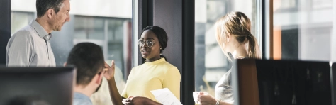 Group of businessmen and businesswomen talking in an office setting