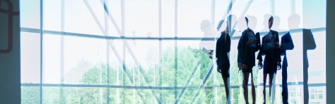 Group of business people standing in an office by a panoramic window