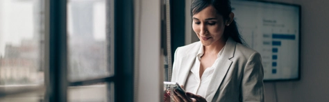 Woman looking on phone at Autumn economic outlook