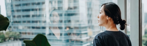 An image of a businesswoman looking out the office window