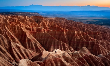 Wide panoramic landscape of desert rock formations at sunrise with dramatic light and horizon view.