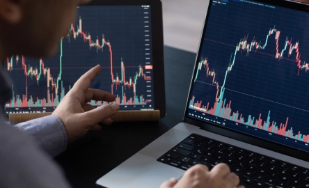 Man checking the stock market and investments using his laptop.