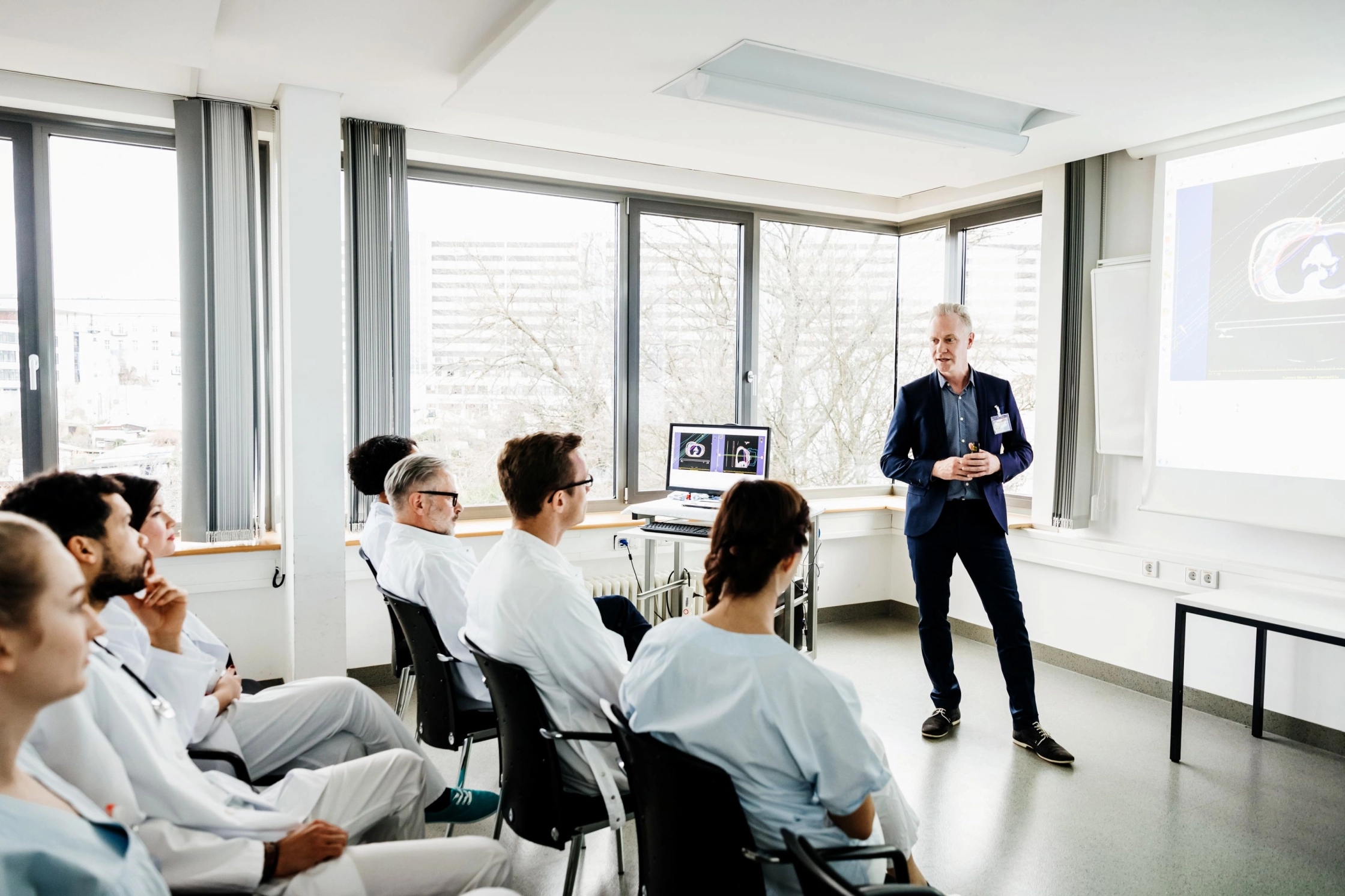 Medical professionals attending a cybersecurity and MedTech presentation in a modern healthcare training environment.