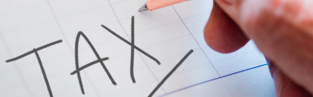 a9c137b18821-Image-of-man-writing-TAX.jpg.webp