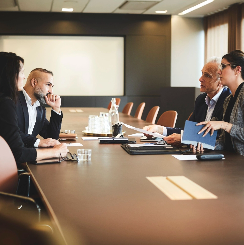 Forensic services professionals in a serious discussion across a boardroom table