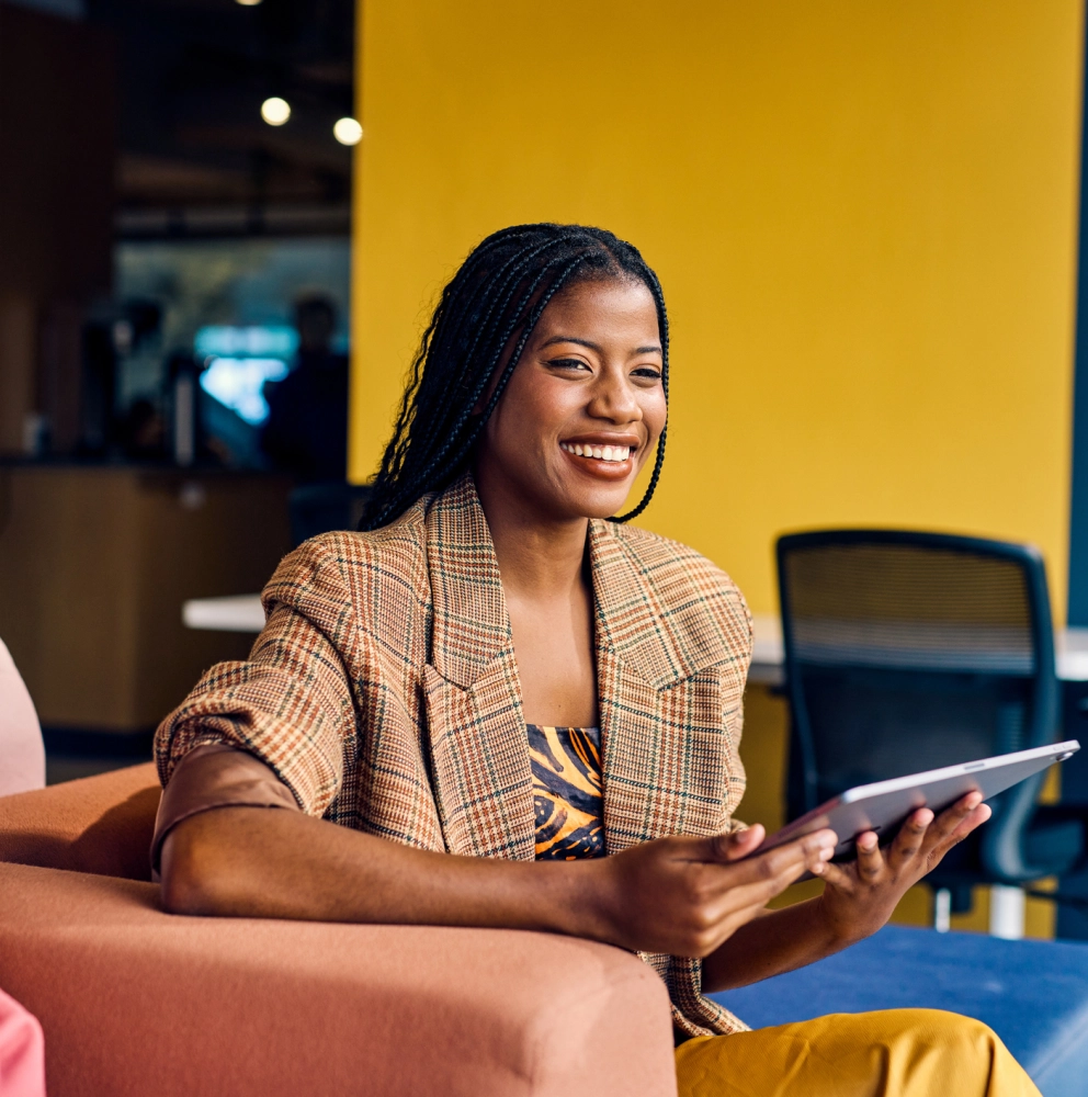 Management consulting. Pessoa em primeiro plano com tablet na mão e sorrindo.