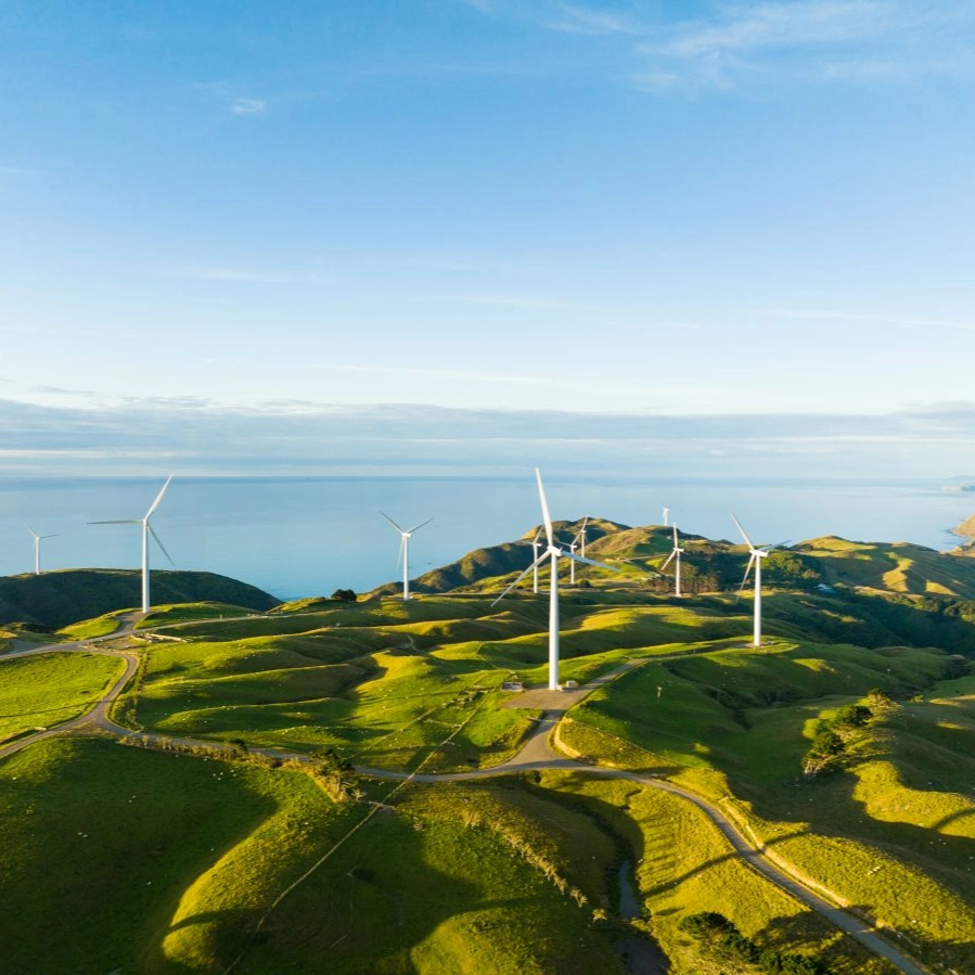 Beautiful scenic view of windmills scattered across the hills with coast in backdrop.jpg