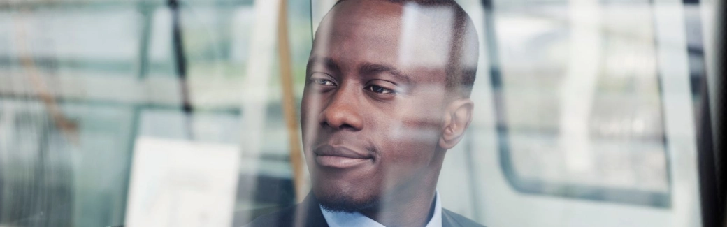 Man looking out window thinking of Prudential Regulation Authority priorities for 2025