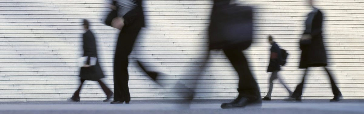 figure sfocate che camminano con una scalinata come sfondo