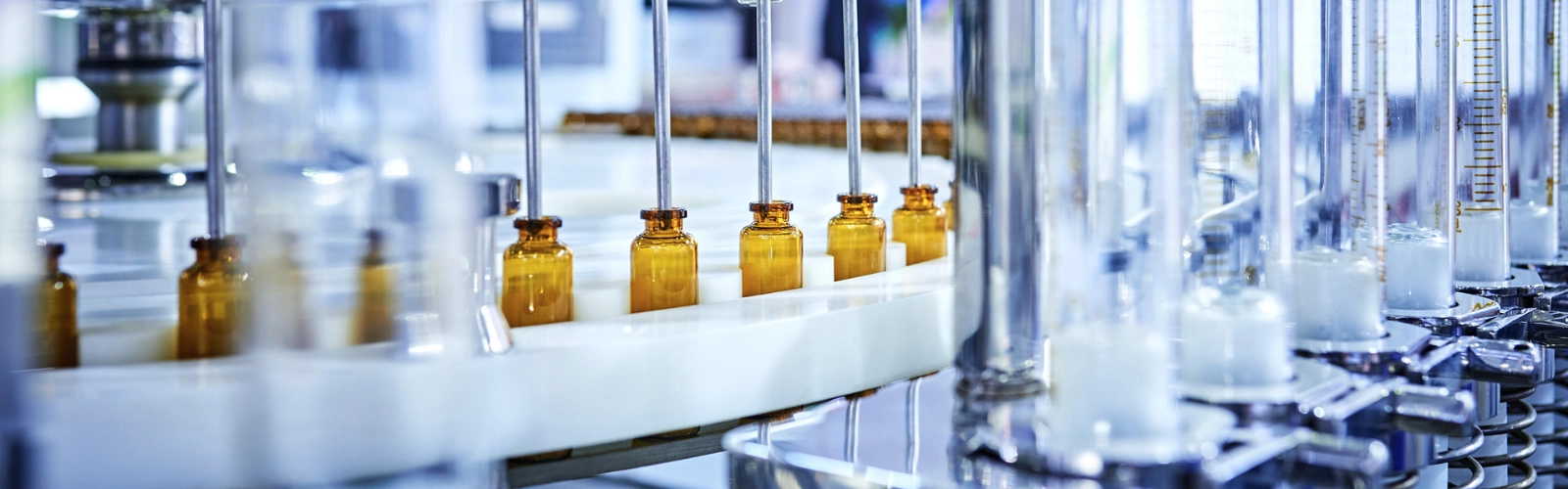 A close-up image of medicine glass bottles on a production line.