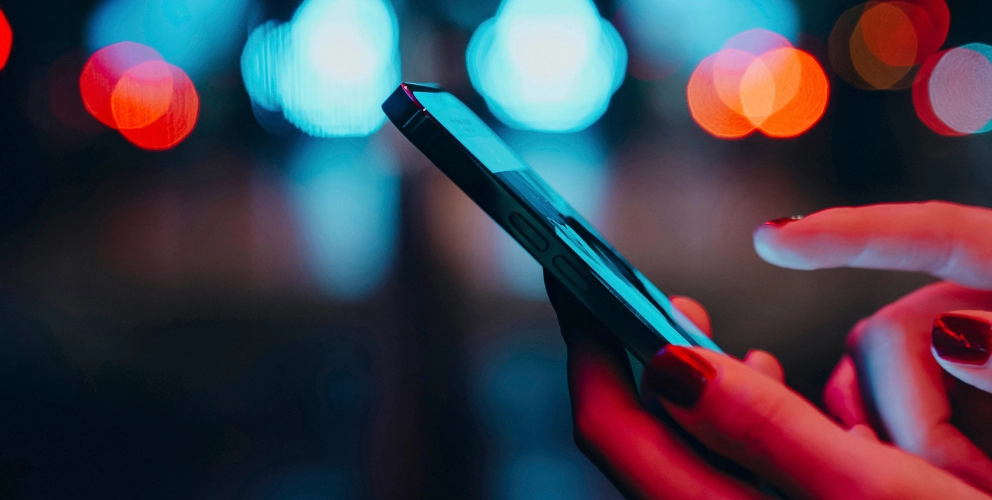 A close up image of a hand holding a telecommunication device.