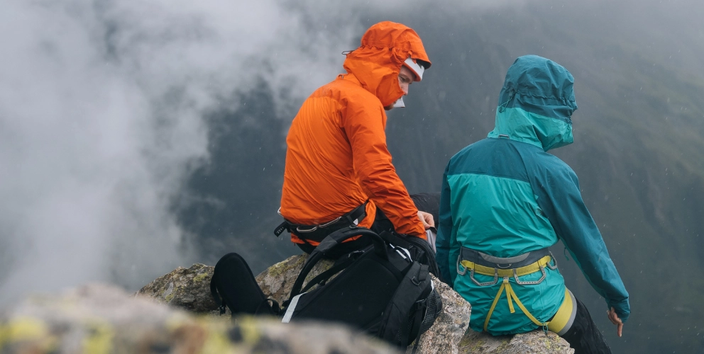 couple sitting on mountain with mist in background